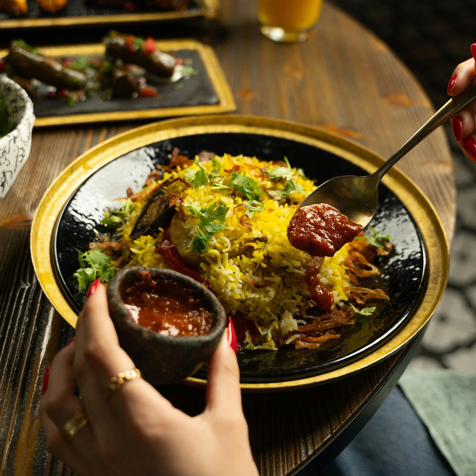 Al Zayt Biryani — saffron-yellow long-grain rice, slow-steamed with Kerala spices, fresh coriander and house-made tomato sauce