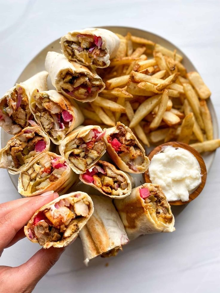 Freshly carved chicken shawarma wraps with crisp fries and garlic toum, authentic Arabic shawarma in Ilford London